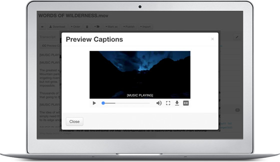 A “Preview Captions” dialog on a laptop playing a night-time mountain scene with the caption “[MUSIC PLAYING]” burned across the bottom of the player.