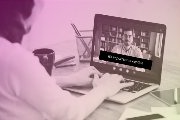 woman watching a video on her laptop with captions on screen