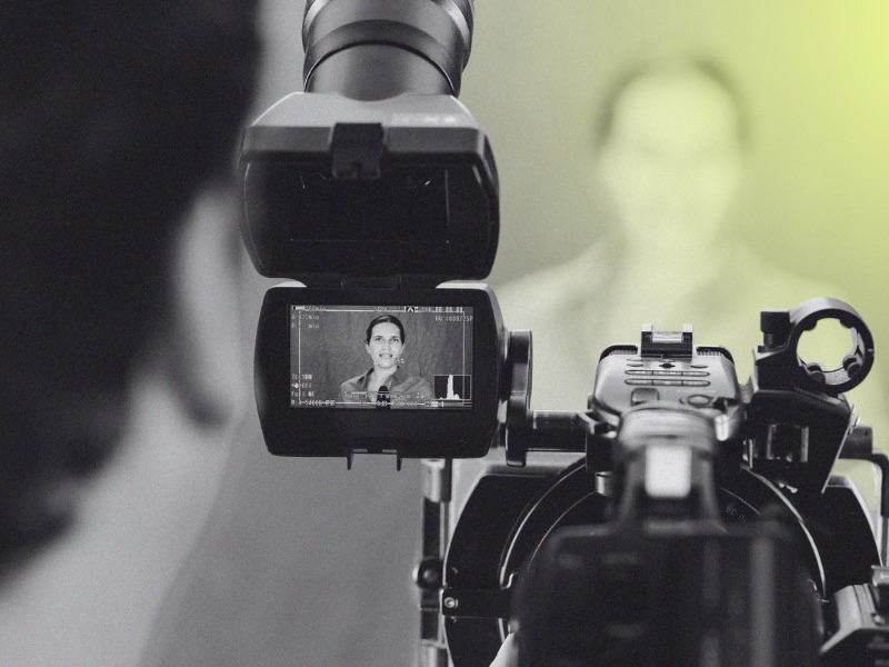 camera filming woman in news studio