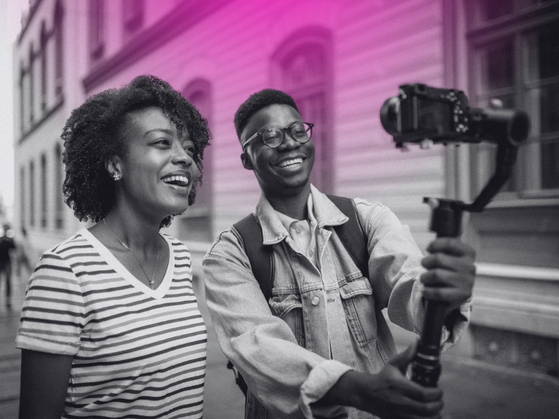 two people filming themselves with a camera on a gimble