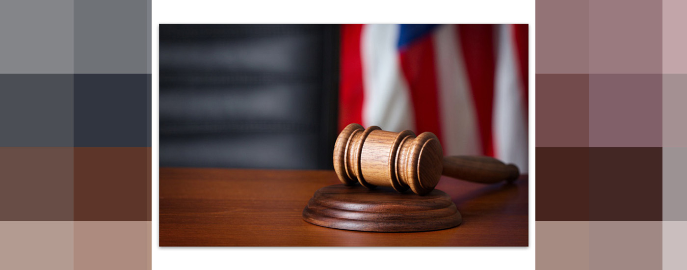 a judges gavel on a desk with the American flag in the background