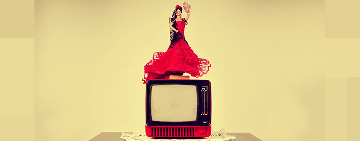 A flamenco dancer doll stands on top of a television