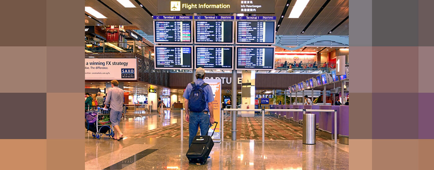 a man in front of flight information at the airport