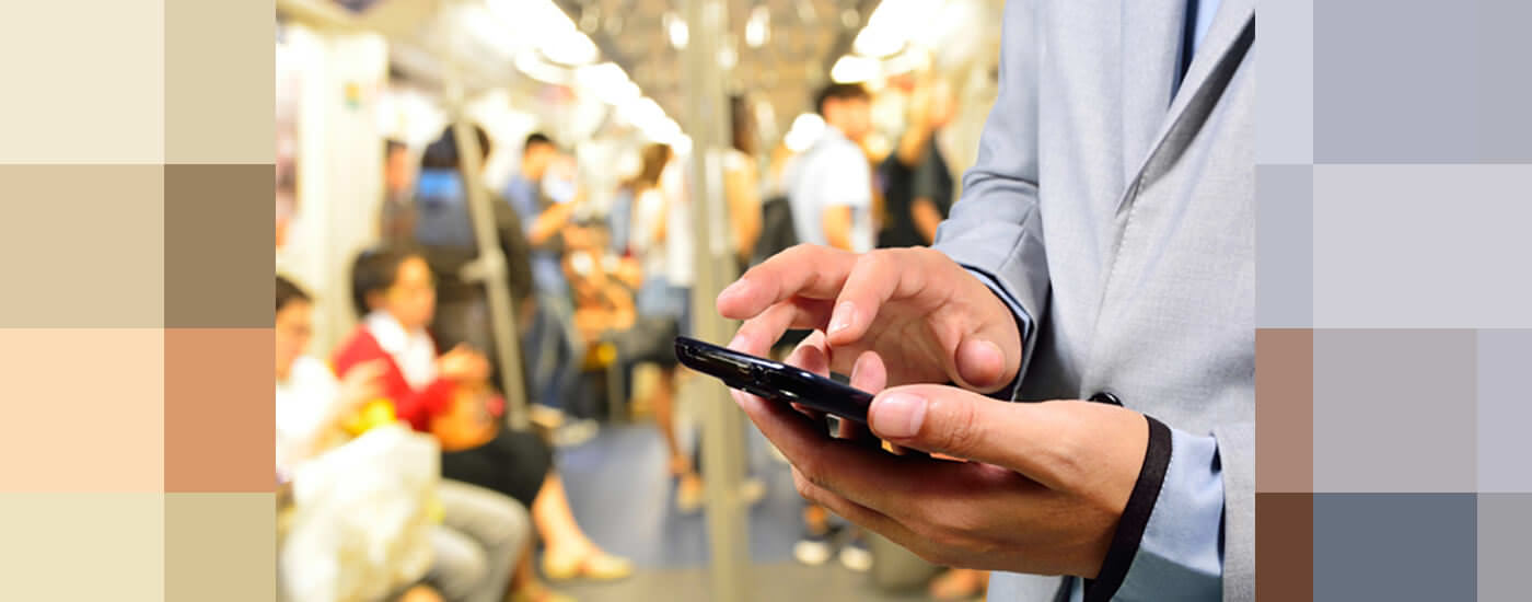 a man on a train scrolling through his phone