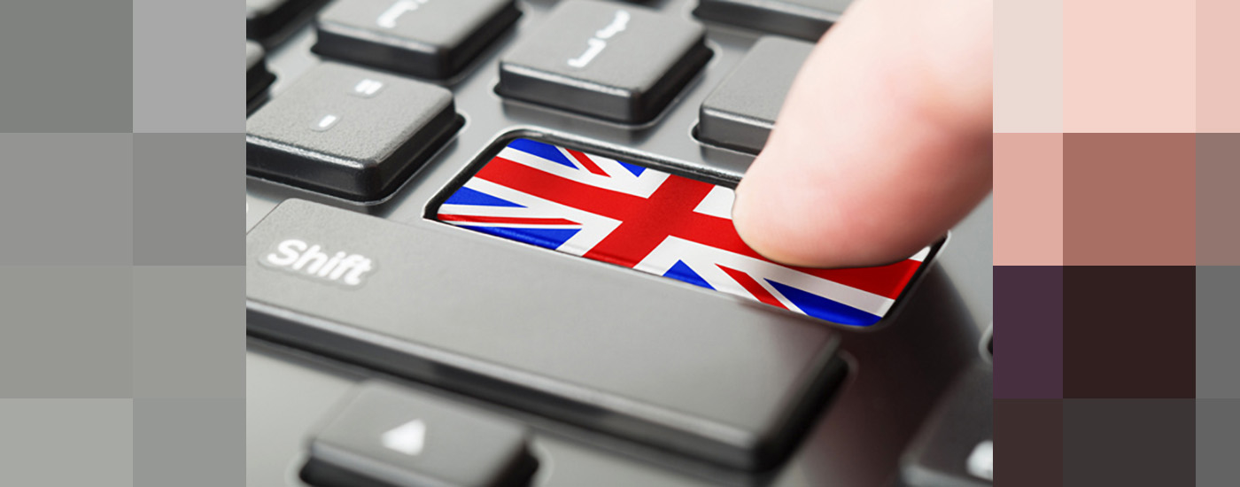 the return key on a keyboard is replaced by a British flag. a finger presses down on the key with the flag