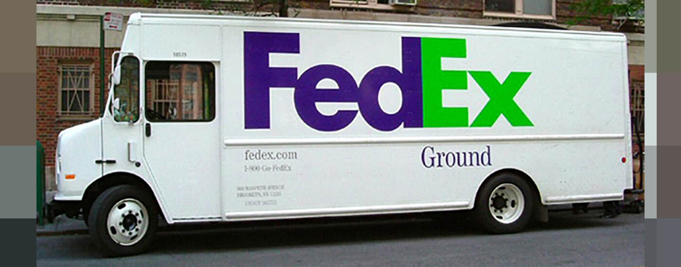 Side view of a FedEx truck parked on a street.