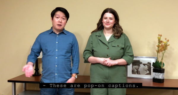 Pop-on captioning example. A man and woman stand side-by-side. A pop-on caption in progress reads "These are pop-on captions."