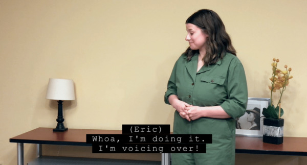 Pop-on captioning example. A woman looks to the side. A pop-on caption reads "(Eric) Whoa. I'm doing it. I'm voicing over."