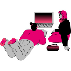 two women sitting on the ground and viewing a laptop