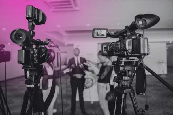 Someone taking an interview behind two video cameras