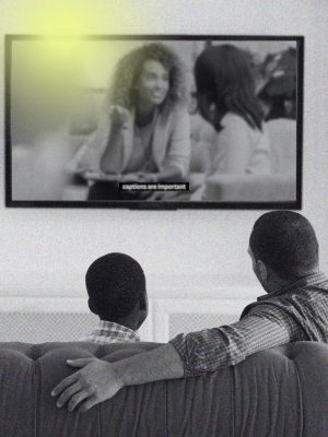 father and son watching TV with captions