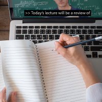 person taking notes on a notebook while watching a captioned video