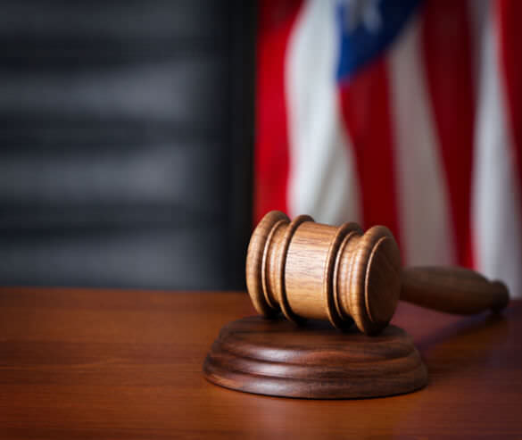 a judges gavel on a desk with the American flag in the background