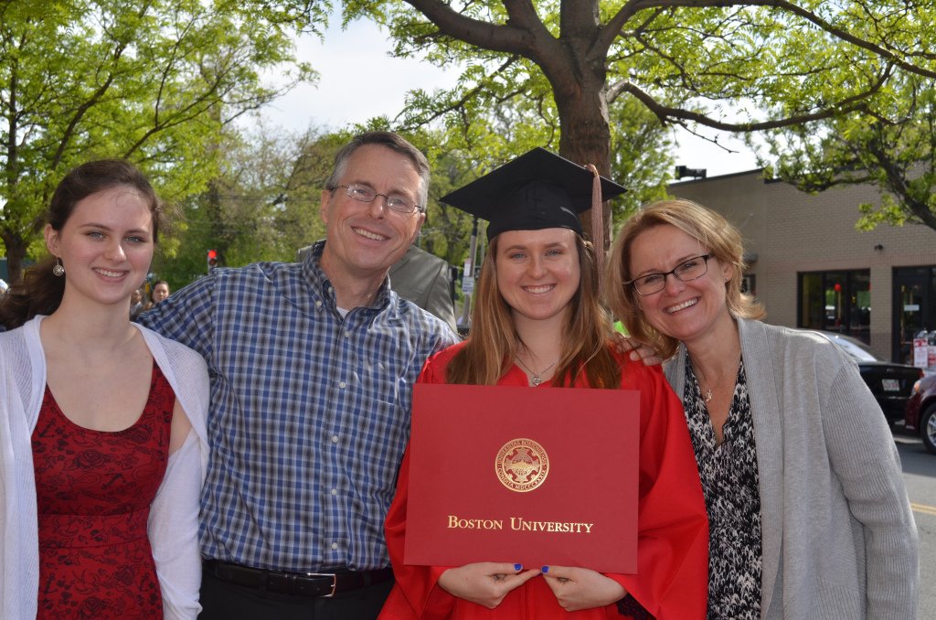 Alanna Kilroy poses in a cap and gown with her degree from Boston University with her mom, dad, and sister