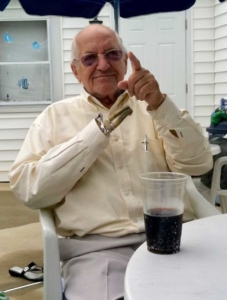 Dustin's grandfather, an older white man with a hook, sits with a drink