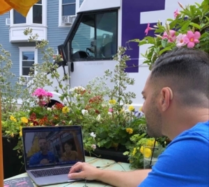 Dustin sits outside with his laptop