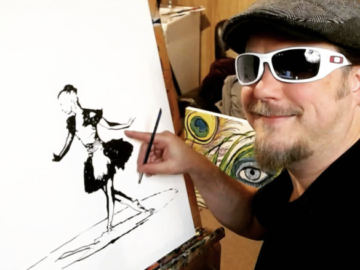 John Bramblitt smiles next to his painting of a ballerina