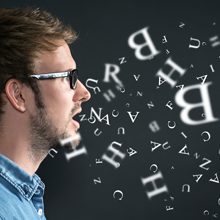 A person's head with letters flying around, coming from his mouth