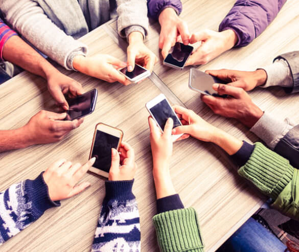 A group of people using their smartphones at a table