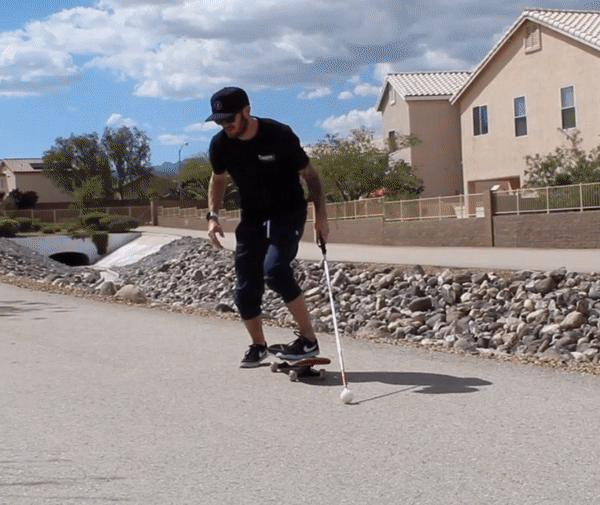 Justin Bishop skateboarding with his white cane
