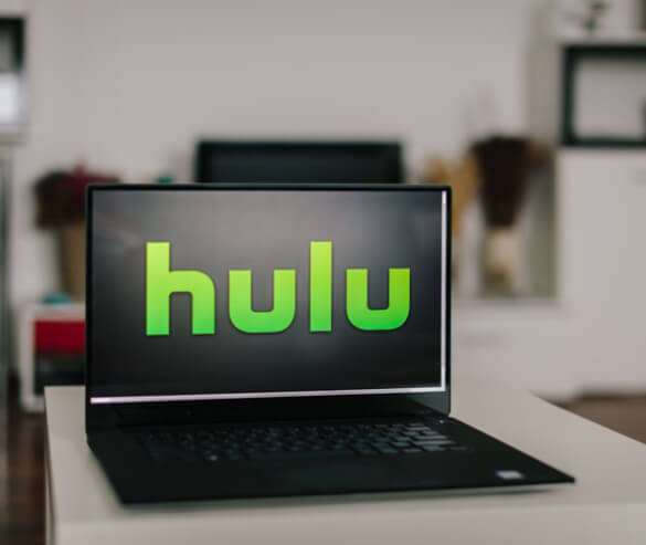 The Hulu logo shown on a laptop screen in a living room.