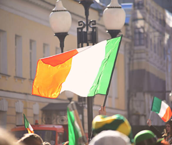 Irish flags being waved in a parade.