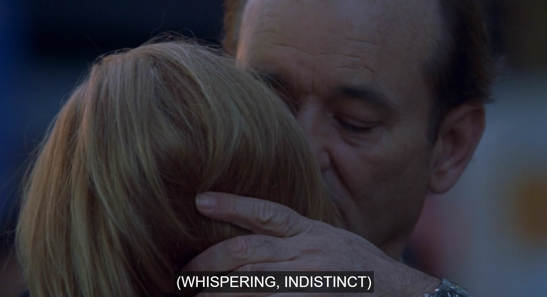 a screenshot of Bill Murray's character whispering into the ear Scarlett Johansson's character. The caption at the bottom reads (whispering, indistinct) in brackets.