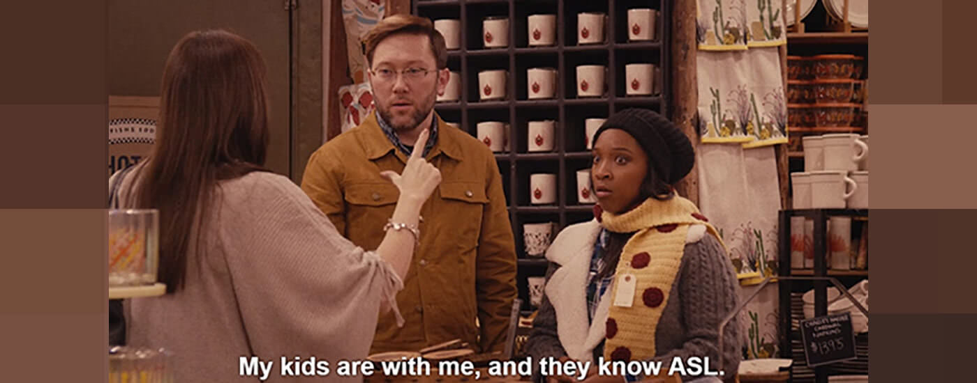 A woman signing to a couple in a home furnishing store. Caption reads: My kids are with me, and they know ASL.